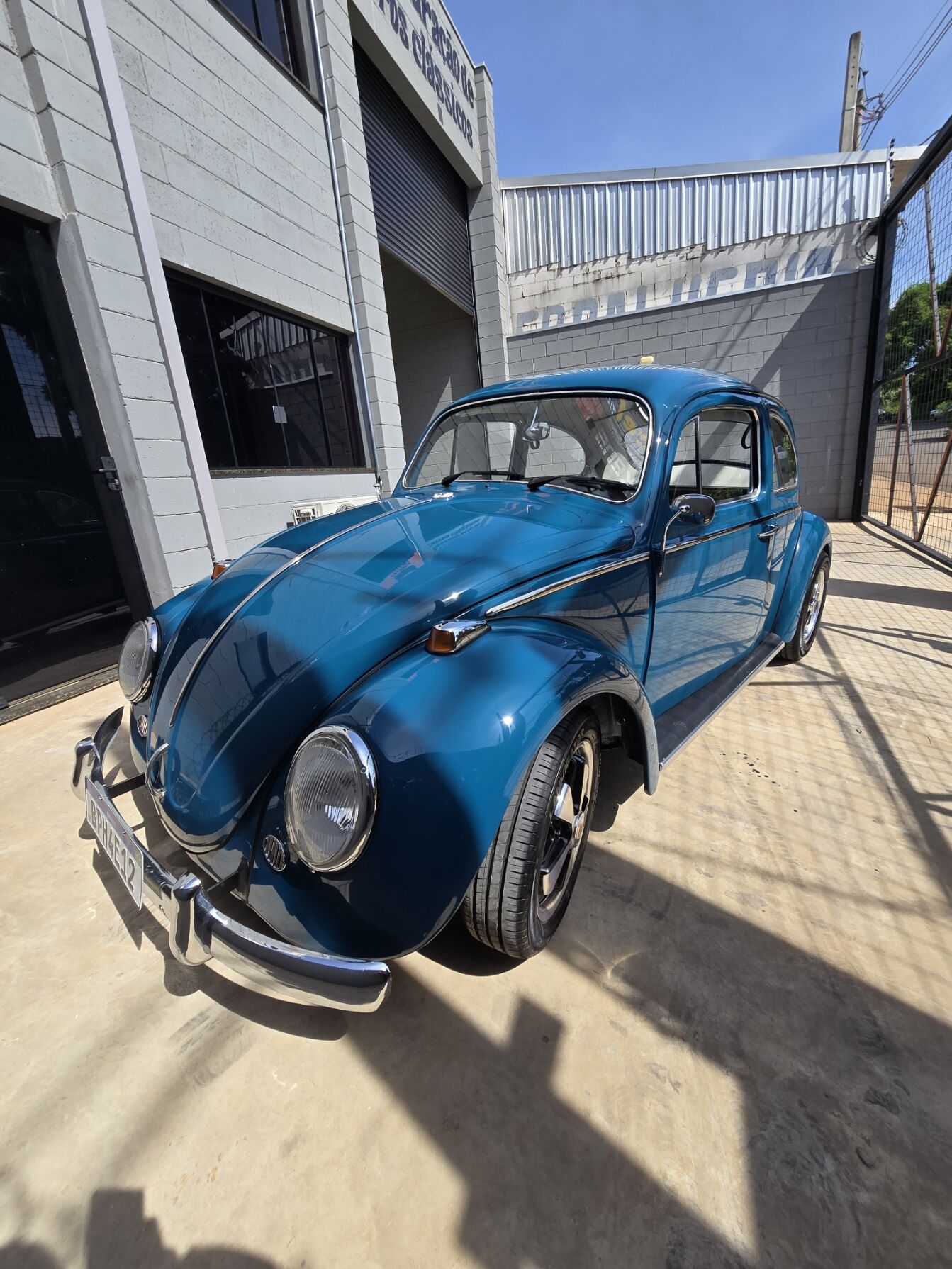 Fusca azul restaurado em frente à oficina